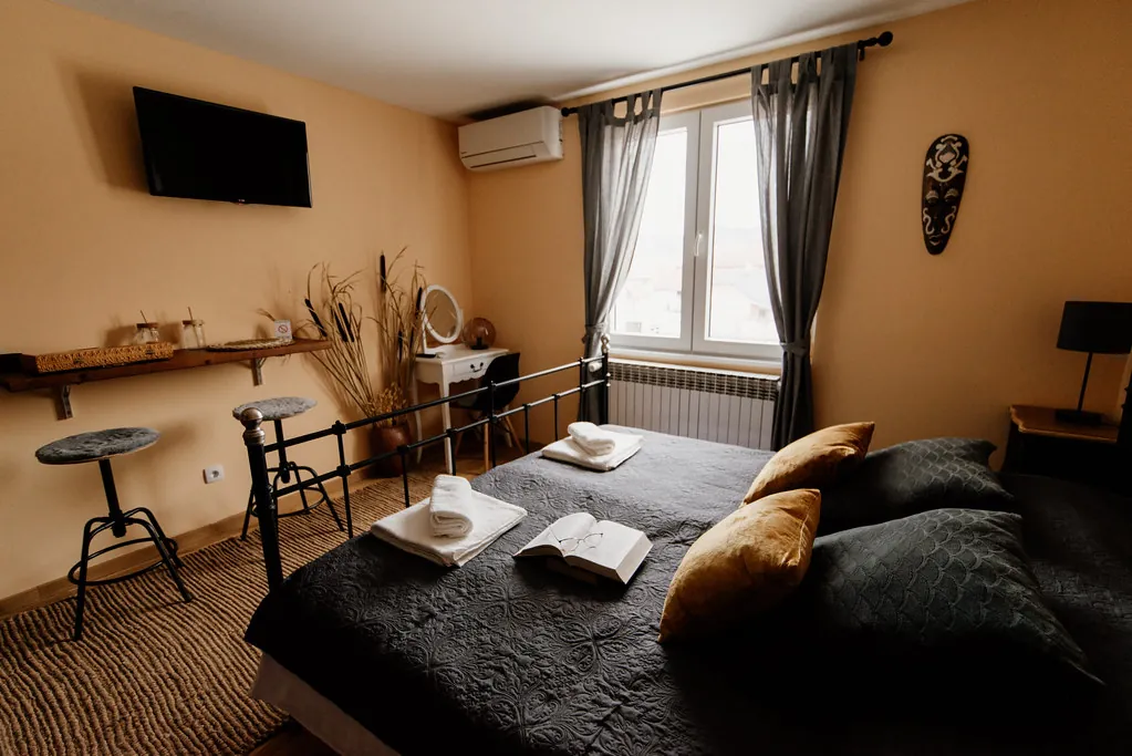 Habitación con cama doble, butacas y ventana
