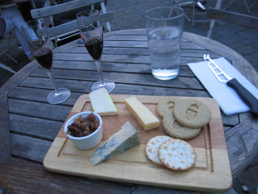 Tabla de quesos y copas de vino en una terraza